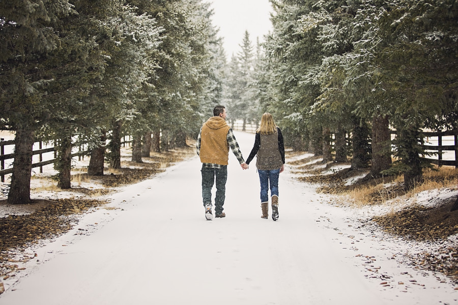 engagement-couple-holding-hands-walking-in-snow